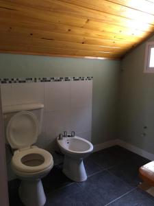 a bathroom with a toilet and a sink at Villa Serena Deportista in Necochea +30 photos