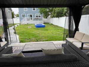 a screened in porch with a couch and a yard at Ground-level bed bath house1mi to the beach sleep8 in Long Branch