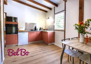 une cuisine avec des placards rouges et une table en bois dans l'établissement Haut de villa BEL BO & Bas de villa Tibo accès mer, à Deshaies 29 autres photos