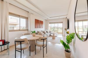 a living room with a table and chairs and a couch at Luxury Appartement Golf and Pool in Marrakech