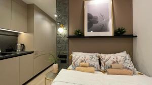 Un dormitorio con una cama con dos almohadas y una cocina. en Burtnieku Apartment - Quiet & Cozy, en Riga