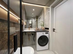 Un baño con lavadora y lavabo. en Burtnieku Apartment - Quiet & Cozy, en Riga