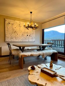 a dining room with a table and a large window at Departamentos Exclusivos Termas de Chillán in Nevados de Chillan