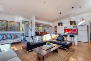 a living room with a couch and a table at Delightful Dicky Beach Holiday House in Caloundra