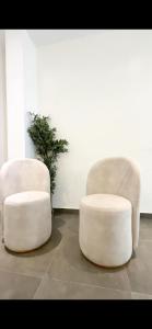 two white chairs and a stool in a room at 3bedroom maisonette Banana, Ikoyi in Ikoyi