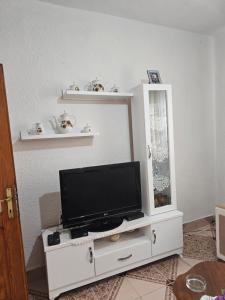 a tv on a white entertainment center with a mirror at Villa Pogradeci in Pogradec