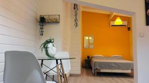 a room with a table and a bed and a yellow wall at Cacao House in Capesterre-Belle-Eau