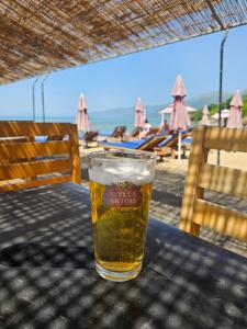 a glass of beer sitting on a table near the beach at Villa Pogradeci in Pogradec