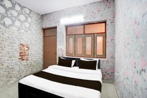 a bedroom with a bed and a window with flowers at Super Hotel O The Comfort in Kānpur +21 photos