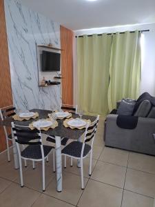 un soggiorno con tavolo da pranzo e sedie di Apê aconchegante bem localizado ad Aracaju Altre 18 foto