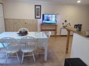 a dining room with a table and chairs and a tv at Casa Llao alojamiento de montaña in San Carlos de Bariloche