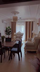 a living room with a table and a couch and chairs at MAISON SUISSE Emana Yaoundé, Appartements meublés de luxe in Yaoundé