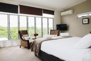 a large bedroom with a large bed and windows at Family Beach House at Twin Waters Resort in Twin Waters