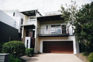 a large white house with a large garage at Family Beach House at Twin Waters Resort in Twin Waters