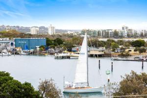 BuddinaにあるPoint Cartwright Penthouse - Ocean and River Viewsの街を背景にした港の帆船