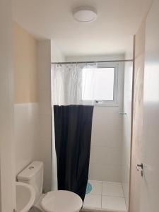 a bathroom with a shower with a toilet and a window at Refúgio do Aconchego Frente Praia Ocean Club in Mongaguá