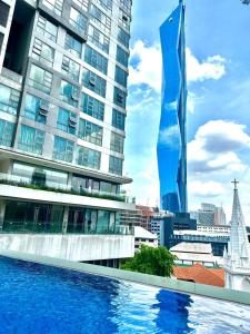 a large building with a pool in front of a building at Home Sweet Home at Robertson Bukit Bintang,TRX,KLCC in Kuala Lumpur