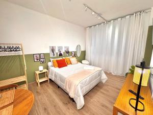 a bedroom with a large bed with orange pillows at Estúdio prático e completo no centro de Nova Friburgo in Nova Friburgo