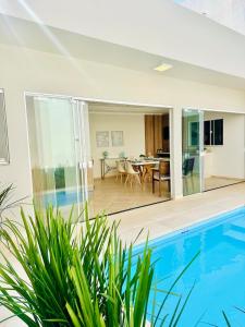 a house with a swimming pool and a dining room at Lindo sobrado central com piscina aquecida in Cascavel