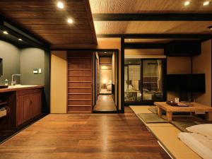 ein Wohnzimmer mit Holzböden und einem Tisch in der Unterkunft Tsumugi Nishinotoinhanayacho in Kyoto