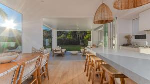 Coen by the Sea في ساحة كاسوارينا: مطبخ مع طاولة طويلة وكراسي خشبية