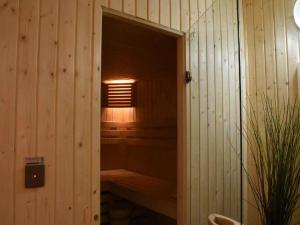 uma porta aberta para uma sauna numa sala de madeira em Spacious 8-Bedroom Chalet, cleaning included em Barvaux