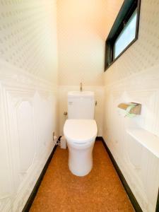 a small bathroom with a toilet and a window at 源泉掛け流し温泉付き貸別荘-Private hot spring & Private house! - THE LOOKOUT KUSATSU in Kusatsu