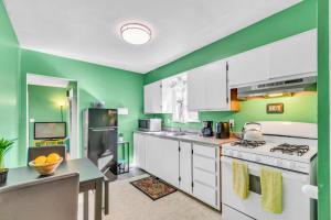 una cocina con armarios blancos y paredes verdes en CoZy CabiN, en Rodeo