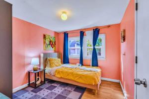 Un dormitorio con paredes naranjas y una cama con cortinas azules. en CoZy CabiN, en Rodeo