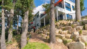 a house on top of a rocky hill with trees at Gyeongju Forest 258 Pet-friendly Pool Villa in Gyeongju
