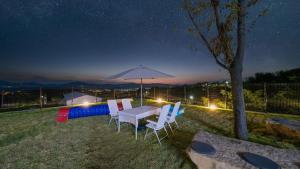 a table and chairs under an umbrella at night at Gyeongju Forest 258 Pet-friendly Pool Villa in Gyeongju