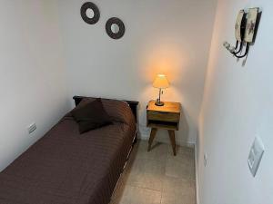 a small bedroom with a bed and a table with a lamp at Nueva Córdoba Ejecutivo in Cordoba +3 photos