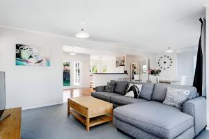 a living room with a couch and a table at Maple Cottage in Taupo