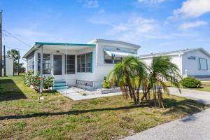 a white house with palm trees in front of it at Peaceful Nokomis Escape 5 Mins to Beach 55 in Nokomis