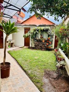 a garden with a house with a palm tree in it at Hotel la Casa de Makito's in Cusco