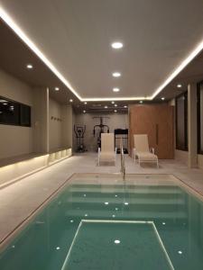 a swimming pool in a building with chairs and a table at Hotel boutique Tramas Andinas in Salta