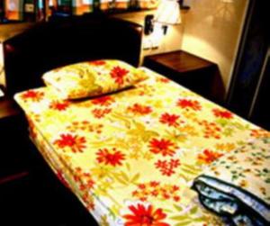 1 cama con edredón de flores y almohada en 1ST Homestay - HK Tai Wan Hostel, en Hong Kong