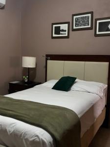 La LimaHotel Lima Park的卧室配有一张白色大床,墙上挂有图片 更多14张照片