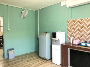 a room with two refrigerators in a room with blue walls at Homestay D'Besut in Kampung Raja