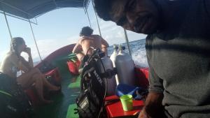 dos hombres sentados en un barco en el agua en Famili Dive Shop, 
