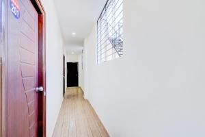 a hallway with a red door and a wooden floor at SPOT ON Hari Hara Enterprises in Maula Ali