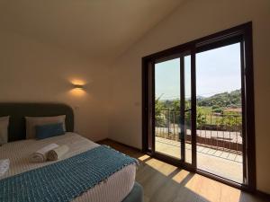 a bedroom with a bed and a large sliding glass door at Casa da Fonte - Gerês in Terras de Bouro +42 photos
