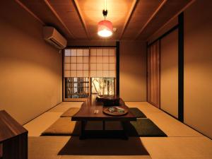 京都松原堺町纺织度假屋的日式客房配有桌子和窗户。