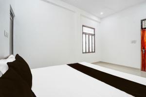 a white room with a bed and a window at SPOT ON Hotel Vardaan in Prayagraj