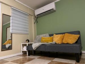 un soggiorno con un divano e uno specchio di Cozy studio in amazing Manatí with AC, WiFi, Pool a Manatí