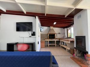 a living room with a tv and a fireplace at Casa Terra Nova - Gerês in Terras de Bouro