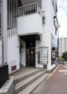 Un edificio blanco con un cartel delante. en 匯金芝浦ビル, en Tokio