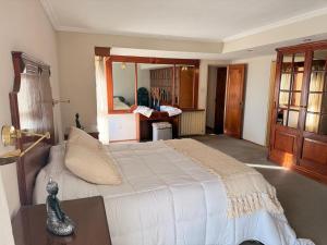 a bedroom with a large white bed and a desk at Decimo in Villa Mercedes
