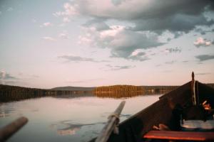 a boat on a lake with a cloudy sky at Ice Hotel in Jukkasjärvi