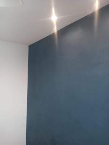a room with a blue wall and lights on the ceiling at Casa de casal in Duque de Caxias